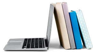 laptop + books Laptop leaning against a stack of colorful books